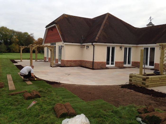 Great care is taken in the finishing touches as Jim makes sure the turf is cut correctly to match the curved lines of the patio on the last day of the build.