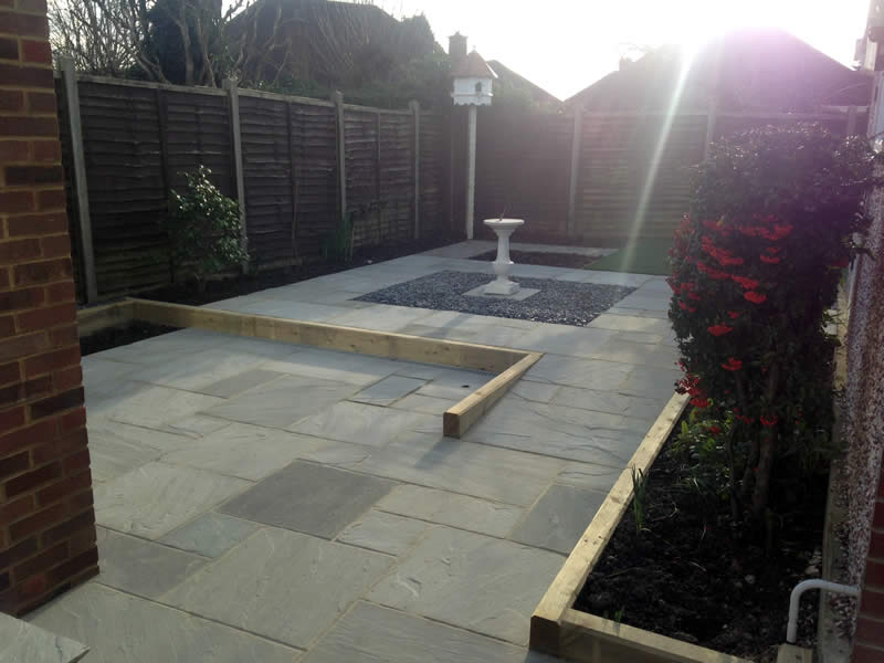 The grey Indian Sandstone used for the paving shows the importance of the use of colour in a garden design.  The subtle grey colour compliments the red brick of the house and ties in nicely with the square area of grey shingle which provides the base for a traditional stone sundial.  Our client didn’t want steps leading to the sundial area so a ramp pathway continuing in the grey sandstone was constructed and edged with timber sleepers, which are an effective way to define areas and add levels in a garden.