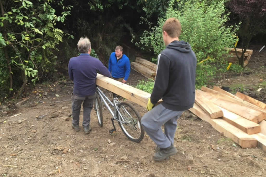 Andy my foreman safely transports the oak sleepers down the slope with the help of Jake and Brett