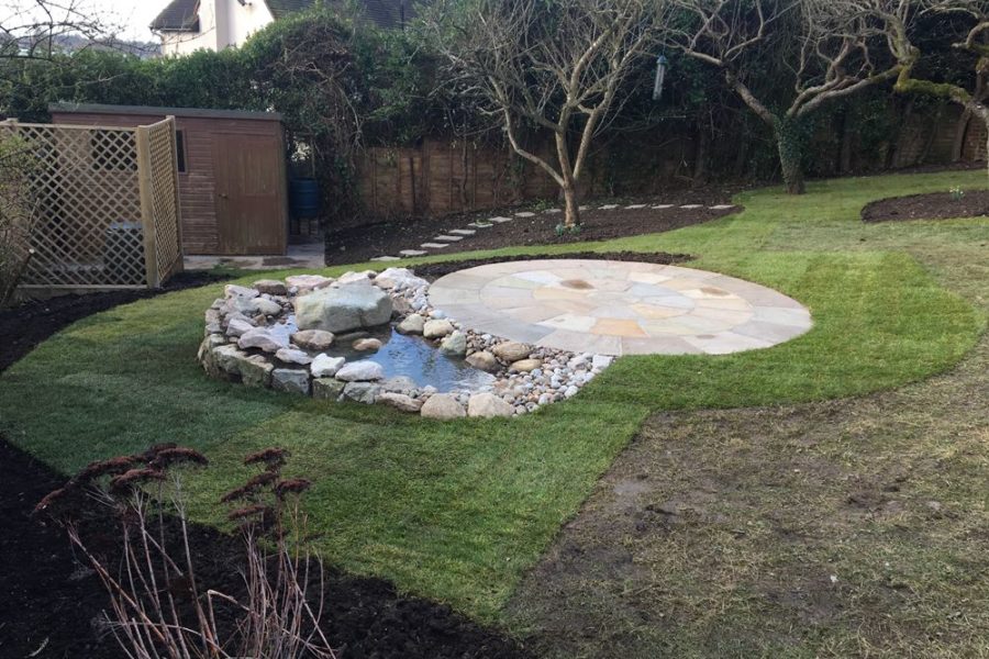 The water feature fits snugly into our clients sloping garden and compliments the circular Indian Sandstone patio area.