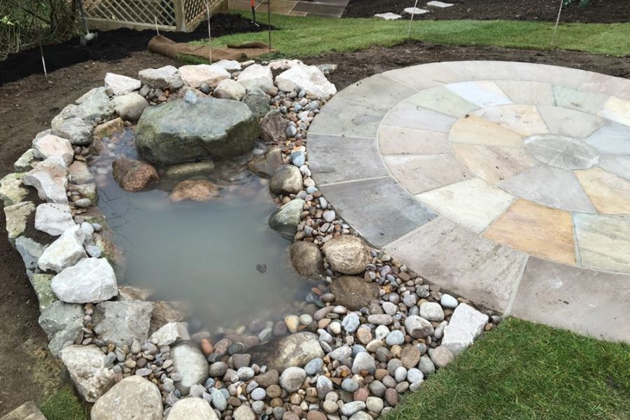Completed water feature revealing the large stone at the far end and the beach area made up of smaller pebbles for the wildlife at the other.