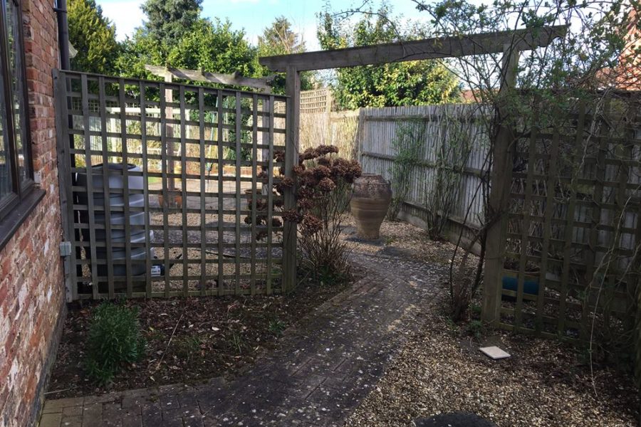 Before photo - the old block pathway and its shingle surround can be seen as well as the arch and trellis.